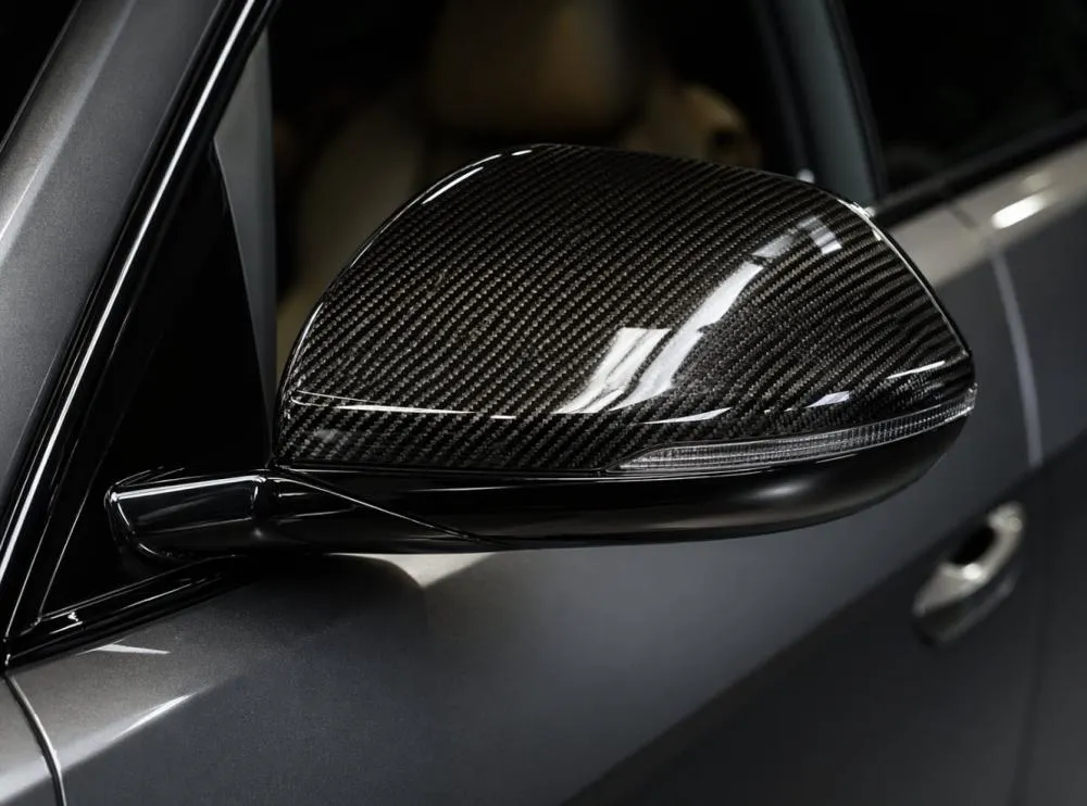 Luxury car side mirror with carbon fiber mirror caps close up